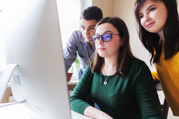 Millennials make a new startup in the office and look at the computer to discuss projects and brainstorm